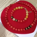 สร้อยข้อมือและสร้อยคอเข้าชุด by velora ผสมผสานหินธรรมชาติระหว่างหินหยกน้ำผึ้ง  :เสริมพลัง ด้านความมั่งคั่งและการเงิน ความหมาย: สีเหลืองทองของหยกน้ำผึ้งสื่อถึงทองคำและความร่ำรวย เชื่อว่าช่วยดึงดูดโชคลาภ เงินทอง และโอกาสทางธุรกิจเข้ามาอย่างต่อเนื่อง เหมาะมากสำหรับผู้ที่ทำธุรกิจส่วนตัวหรือค้าขาย  ,หินปะการังแดง (Red Coral) หรือที่รู้จักกันในชื่อ "กัลปังหาแดง" เป็นอัญมณีที่กำเนิดจากสิ่งมีชีวิตใต้ท้องทะเลลึก มีความพิเศษมีพลังที่เชื่อมโยงกับธาตุน้ำและธาตุไฟในเวลาเดียวกัน  เสริมพลัง ด้านความมั่งคั่งและโชคลาภ เชื่อว่าเป็นสัญลักษณ์ของความอุดมสมบูรณ์  ช่วยดึงดูดความมั่งคั่ง ความสำเร็จในหน้าที่การงาน และช่วยให้การเจรจาทางธุรกิจราบรื่น  ข่วนได้ง่าย  การดูแลรักษา: ควรหลีกเลี่ยงการสัมผัสกับสารเคมี น้ำหอม หรือความร้อนสูง เพราะอาจจะทำให้สีซีดจางหรือเนื้อหินเสียหายได้  คุณสนใจจะนำปะการังแดงมาดีไซน์ร่วมกับหินชนิดอื่นในคอลเลกชัน VELORA เพื่อเสริมเรื่องการปกป้องและความมั่งคั่ง - 1